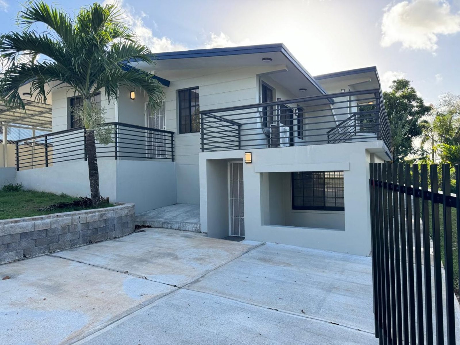 Completed home renovation in Tamuning, Guam, with a rebuilt stair entrance and extended balcony
