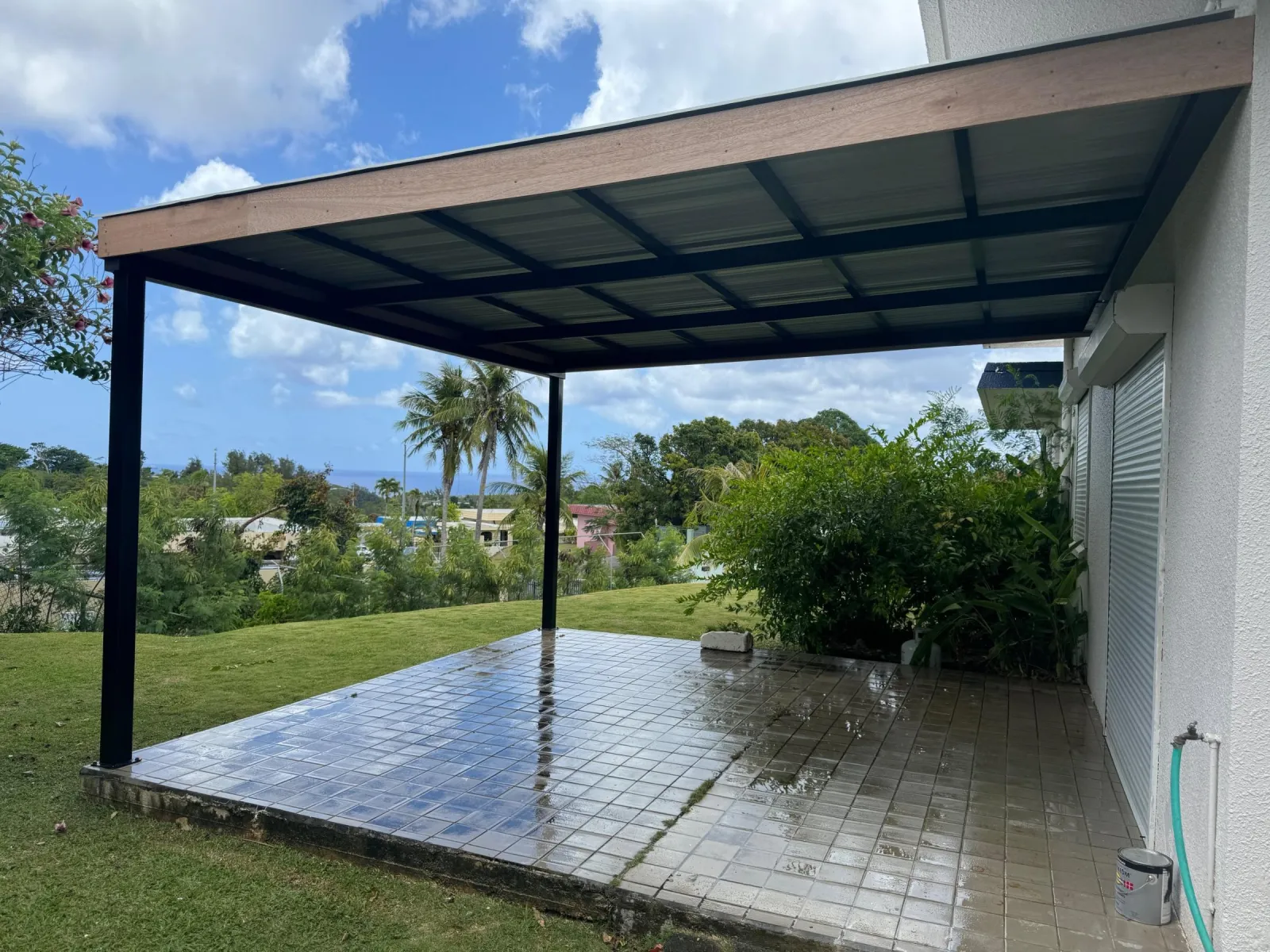 Steel patio canopy set over tile, facing the ocean.