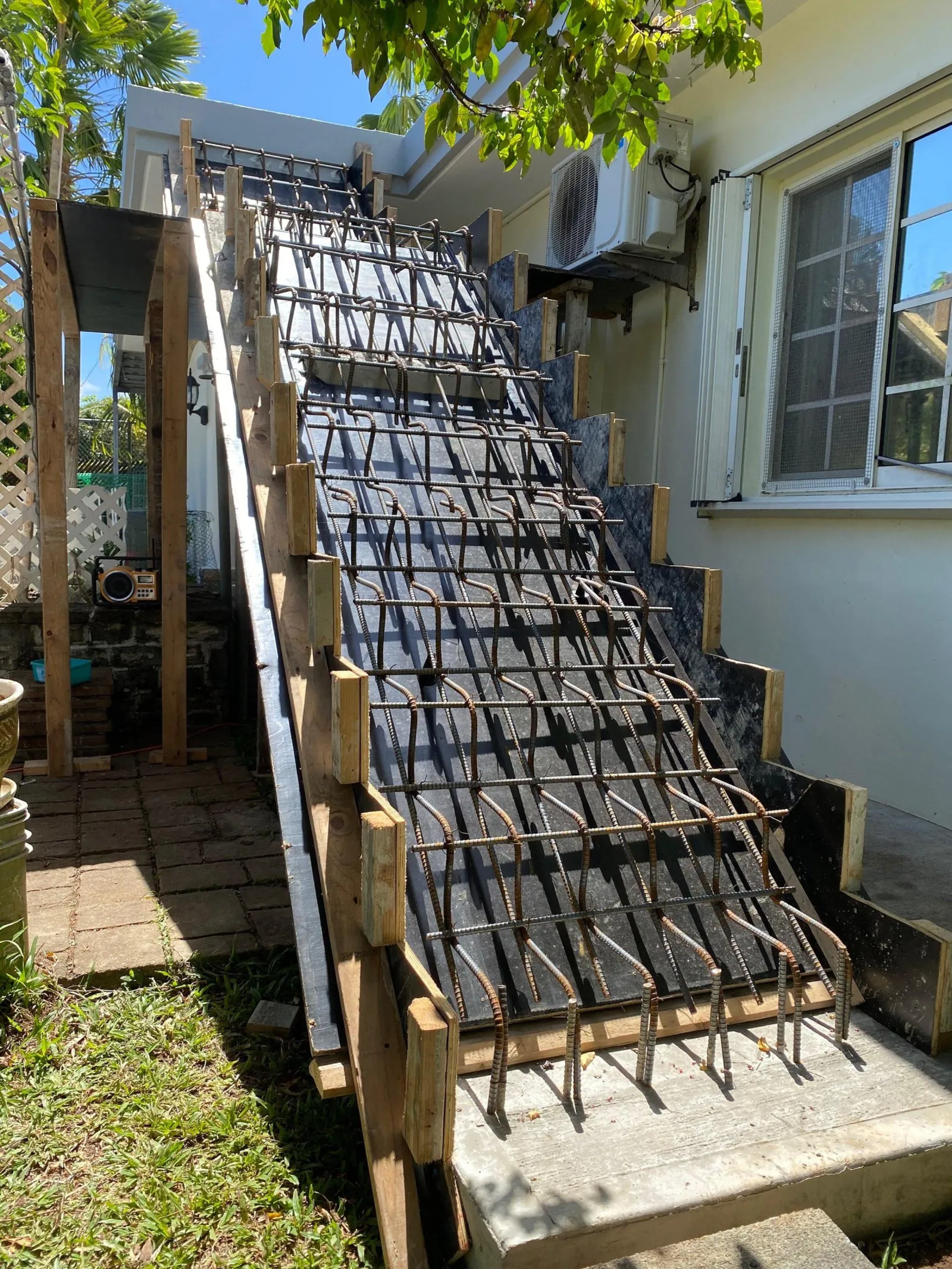 Steel rebar tied over timber formwork on an exterior concrete stairway, ready for a pour